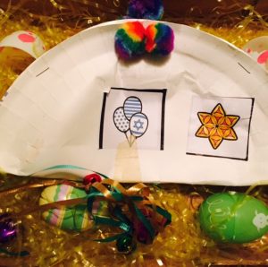 Ruthie's Purim grogger nestling in with her Easter eggs