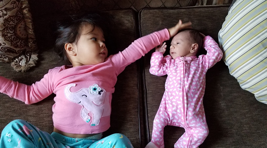 Anna's daughters laying on a couch together